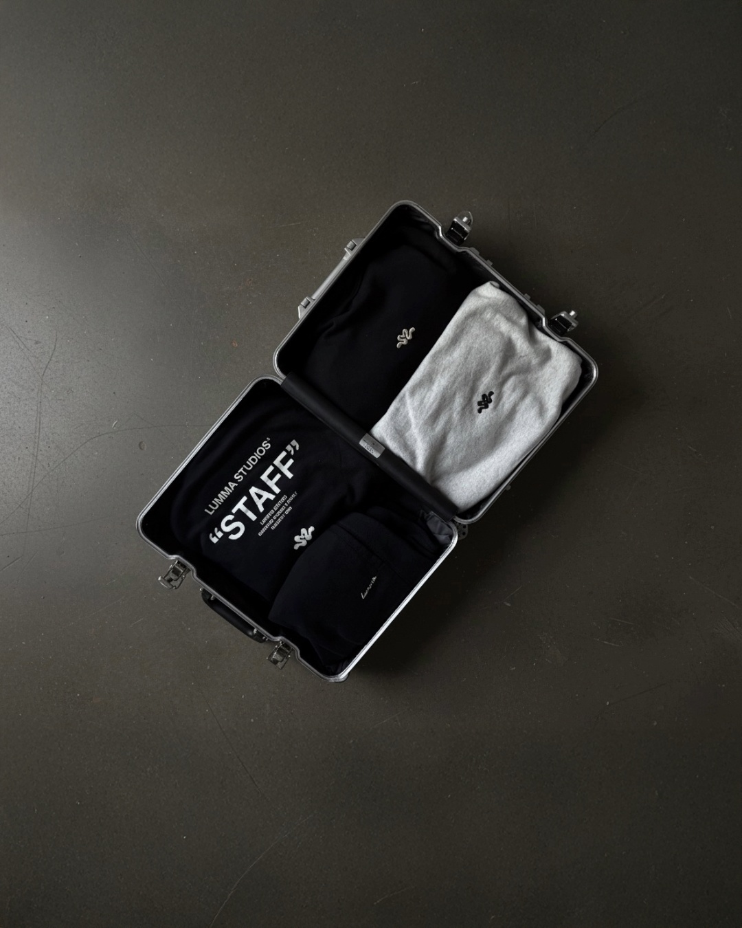 Black travel case with 'STAFF' label on hoodies.